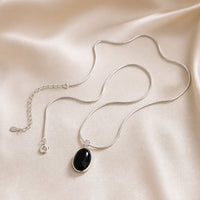 Sophisticated Black Oval Pendant Necklace in White Gold