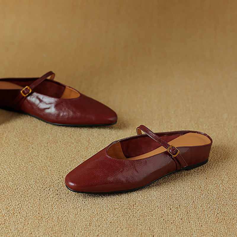 Top-down view of a strap leather flat mule