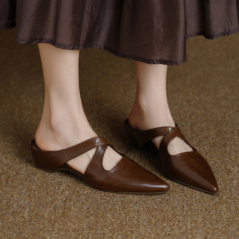 Curved cross-strap detail on a leather mule