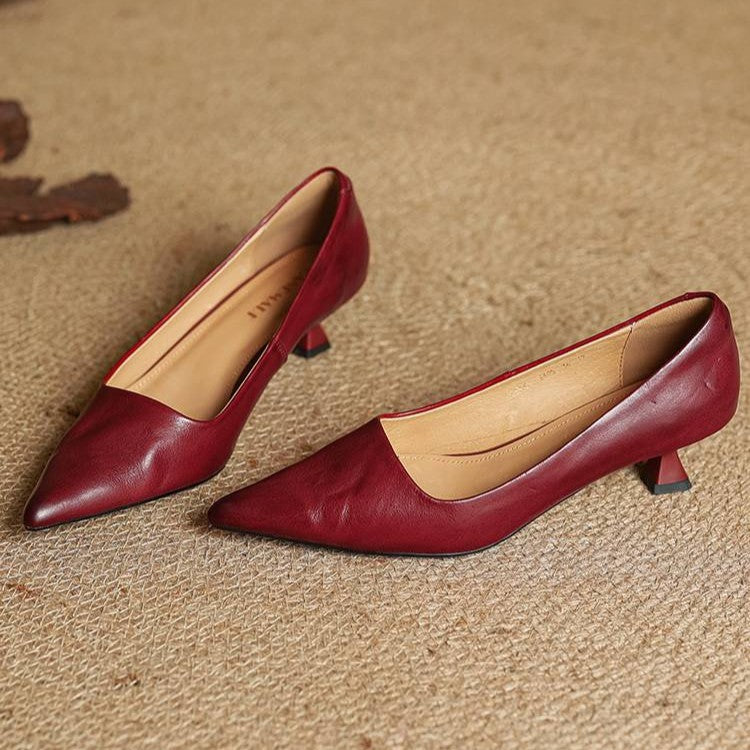 Slip-on detail of a pointed leather kitten heel