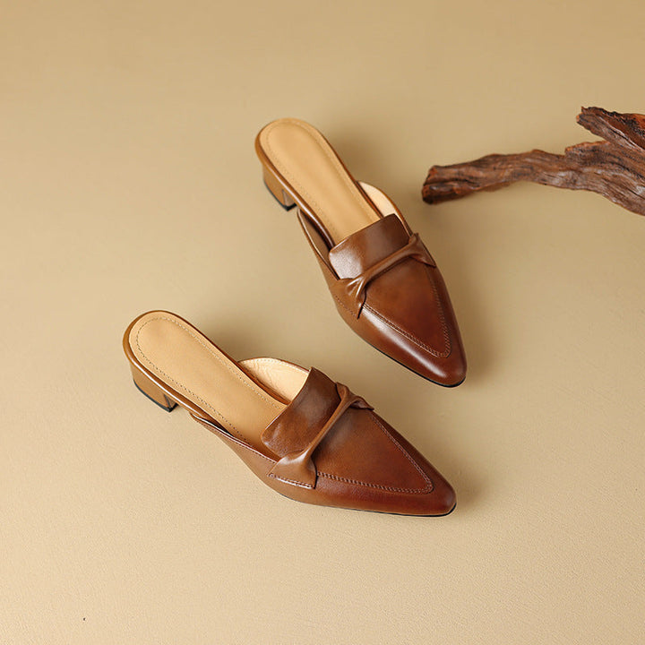 Pointed leather mules styled with tailored trousers