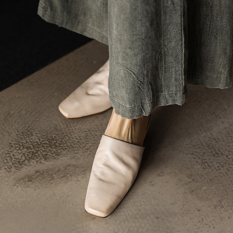 Closed square-toe detail of a leather wedge mule
