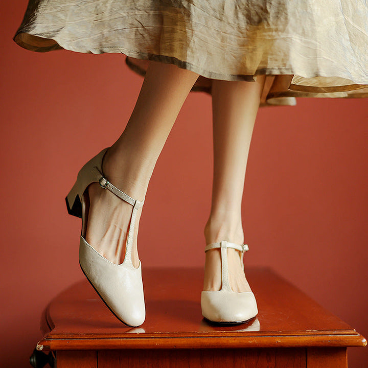 Adjustable T-strap and buckle detail on a leather heel